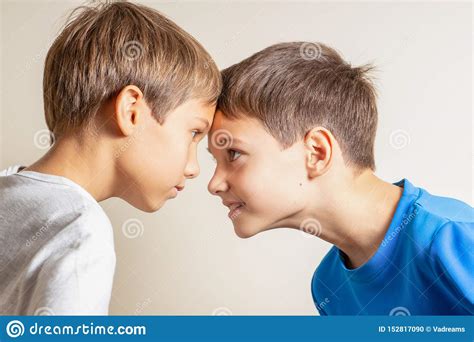 Two Angry Boys Standing Face To Face Quarreling And Looking At Each
