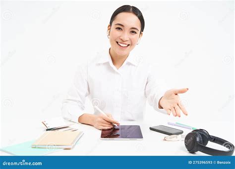 take a seat smiling asian office worker manager invited person to her table works on tablet