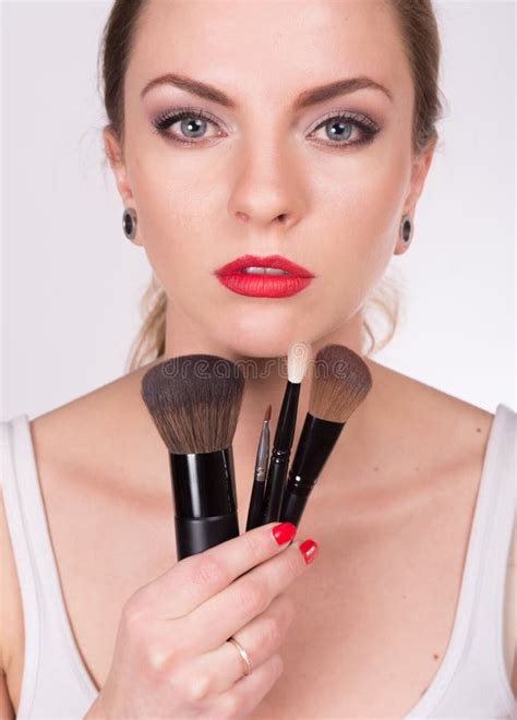 Young Beautiful Woman Holding A Brushes Under Her Face Stock Photo