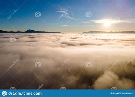 Aerial View Of Vibrant Sunset Over White Dense Clouds With Dark