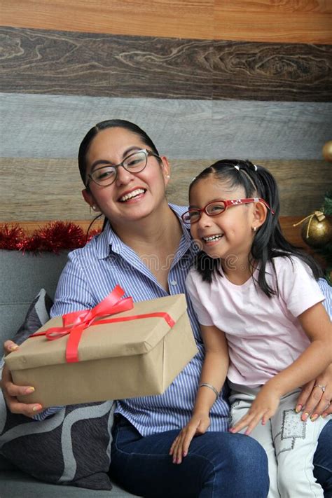 divorced single mom and daughter latina brunettes with glasses have christmas presents sitting