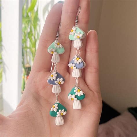 A Person Is Holding Some Pretty Earrings In Their Hand And It Looks