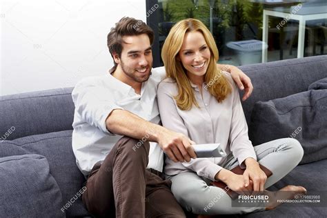 Happy Couple Sitting Together On Couch Watching Tv Show — Side By Side Domestic Life Stock
