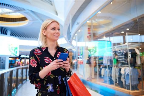 Free Photo Young Woman Using Mobile Phone In Shopping Mall