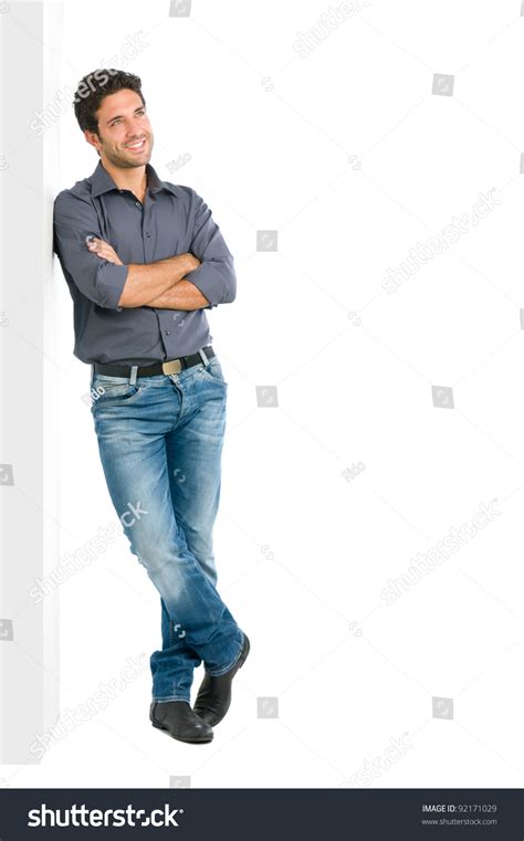 Happy Smiling Young Man Leaning Against White Wall With Dreaming And