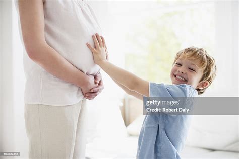 Smiling Son Touching Pregnant Mothers Stomach High Res Stock Photo