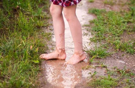 Premium Photo Barefoot Girl Walks Through A Puddles Of Water After