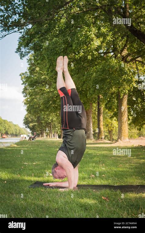 Strong Man Does A Hard Twisted Upside Down Yoga Pose A Variation Of