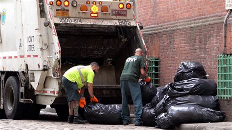 Two Men Loading Trash Into Garbage Truck In New York 4k Stock Video