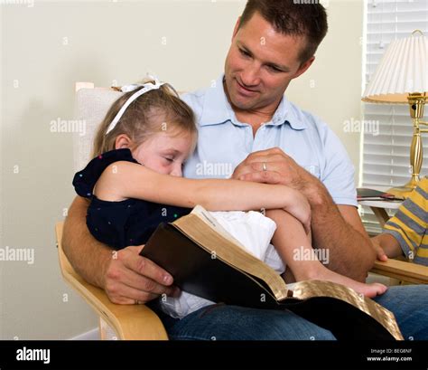 A Sweet Little Girl Falls Asleep In Her Fathers Lap While He Is