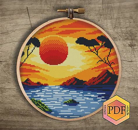 The Cross Stitch Pattern Is Showing An Orange Sunset And Some Trees In