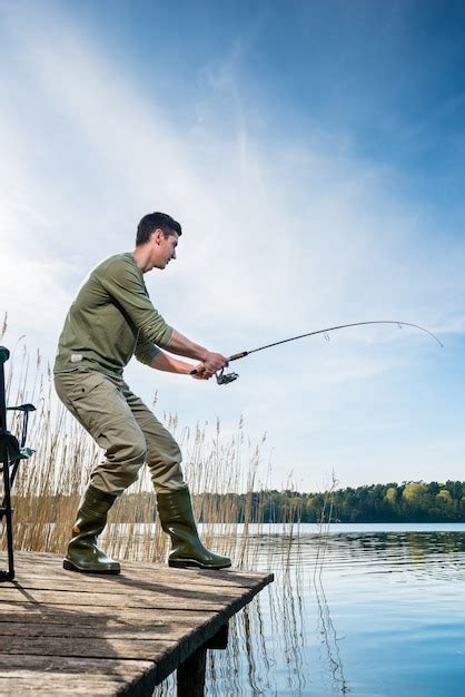 Premium Photo Fisherman Catching Fish Angling At The Lake