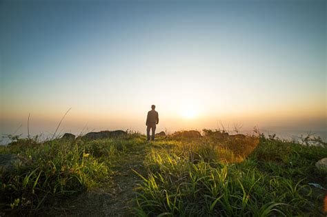 Man Walking Near Sunset On Top Of Mountain Stock Photo Download Image