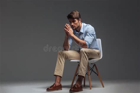 Thoughtful Handsome Young Man Sitting On Chair And Looking Away Stock Image Image Of Blue