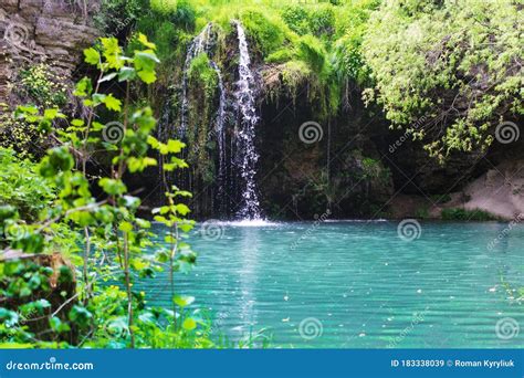 Waterfall That Flows Into A Blue Lake With Clear Water Stock Image