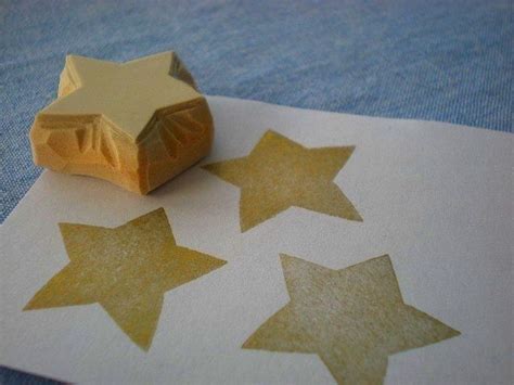 Three Gold Stars On White Paper Next To A Rubber Stamp