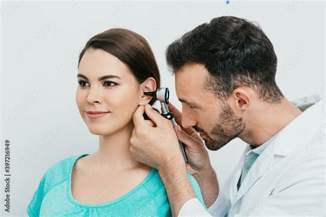 Otolaryngologist Checking Adult Female Ear Using Otoscope Hearing Exam
