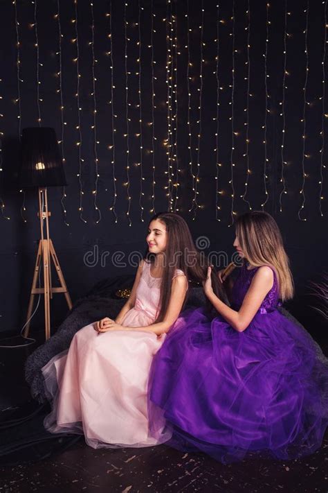 Twee Mooie Meisjes In Blauwe Kleding In Studio Met Decor Van Bloemen In