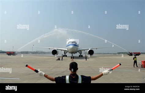 A Chinese Ground Crew Member Directs An Airbus A350 900 Jet Plane Of