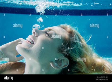 Cropped Underwater View Of Young Woman In Swimming Pool Releasing