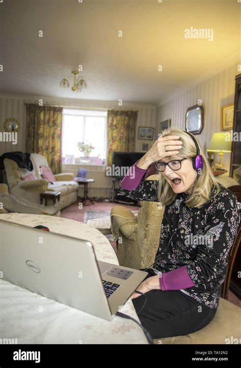 A Shocked Mother At Home Online Looking At Her Computer Screen