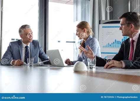 Business People Having Discussion At Table In Board Room Stock Photo
