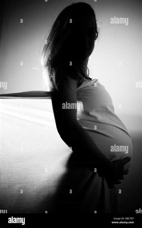 Silhouette Of A Pregnant Woman Holding Her Belly Black And White Stock