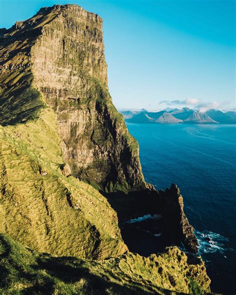 Brown Hill Near Body Of Water Under Blue Skies Photo Free Faroe