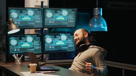 Cyber Criminal Celebrating Hacking Success In Office At Night Stock