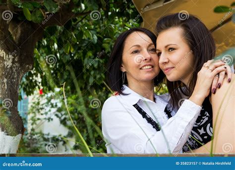 Mother And Teenage Daughter Hugging And Smiling Together Stock Image