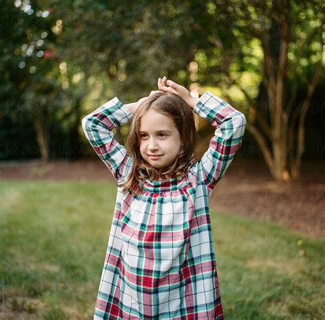 Portrait Of A Cute Young Girl In A Flannel Dress Looking Away Del Colaborador De Stocksy