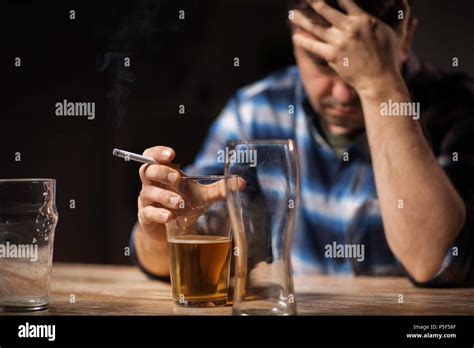 Drunk Man Drinking Alcohol And Smoking Cigarette Stock Photo Alamy