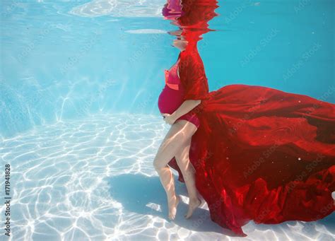 foto de pregnant woman swim dive pose underwater in swimming pool with red fabric aqua