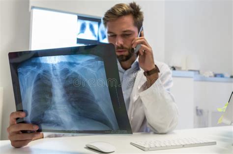 Serious Attractive Doctor And A Nurse Examining An X Ray Stock Photo