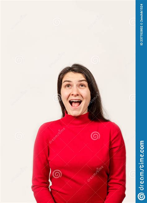 A Brunette Woman In A Red Sweater Laughs With Her Mouth Open And Looks