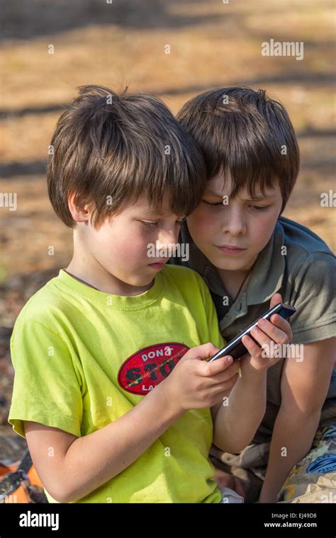 Los Niños Dos Niños Jugando Al Aire Libre De Teléfono Móvil Fotografía