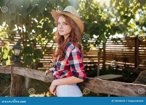 Cute Smiling Redhead Cowgirl In Hat Leaning On Ranch Fence Royalty Free