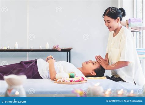 Thai Massage Therapist Giving Head And Facial Massage To An Asian Woman In Thai Traditional Spa