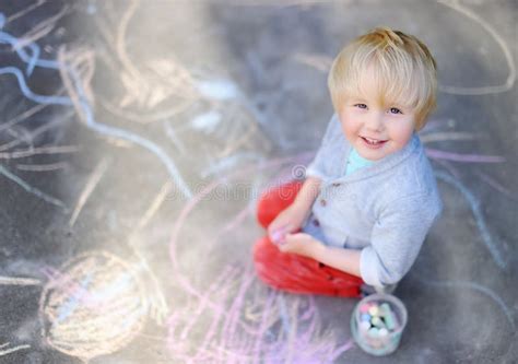 Assento Feliz E Desenho Do Menino Da Criança Com Giz Colorido No Asfalto Foto De Stock Imagem