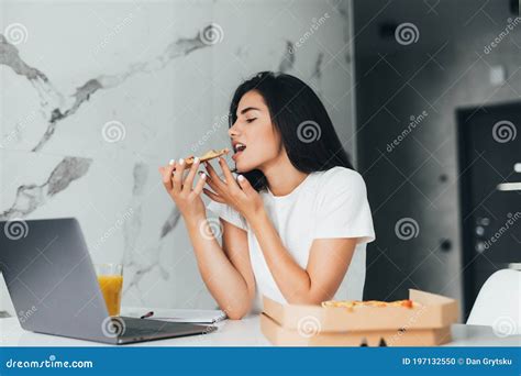 Mulher Jovem Sobrecarregada Fazendo Uma Pausa E Comendo Pizza Trabalhando Em Casa No Laptop Foto