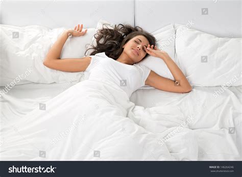 Young Woman Sleeping On The White Linen In Bed At Home Top View Stock