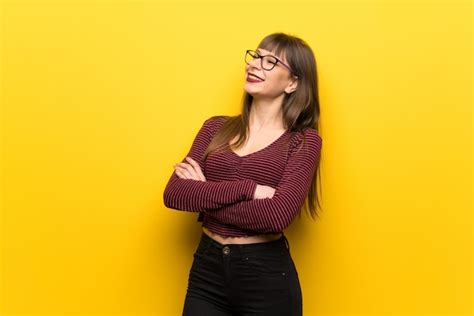 premium photo woman with glasses over yellow wall happy and smiling