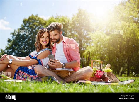 A Photo Of Young Couple Having Sunday Picnic The Man Is Showing Hif