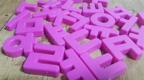 Set Of Plastic Alphabet Letters Placed On A Wooden Floor Stock Photo