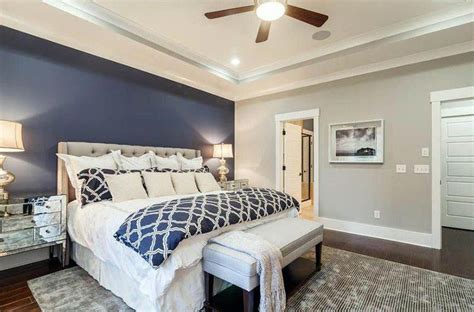 With soothing coastal tones, smart technology accessories, and sumptuous bedding, this expansive bedroom makes beauty rest a breeze. Master bedroom with light gray walls and dark blue accent ...