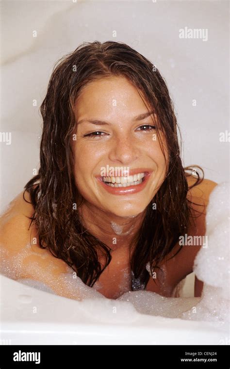 Female With Long Wet Brunette Hair In Bath With Bubble Bath Looking To Camera Smiling Stock