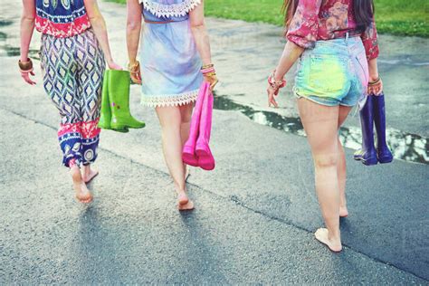 Waist Down View Of Young Women Walking Barefoot At Festival Stock