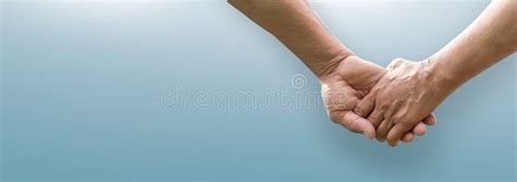 Senior Couple Holding Hands Together On Isolated Blue Background Stock