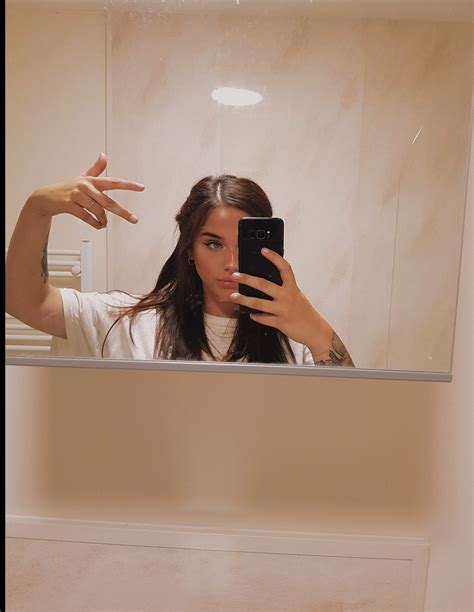 A Woman Taking A Selfie In Front Of A Mirror