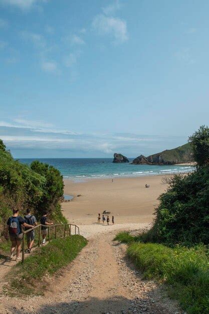 Un Grupo De Personas Caminando Por Un Sendero Hacia La Playa Foto